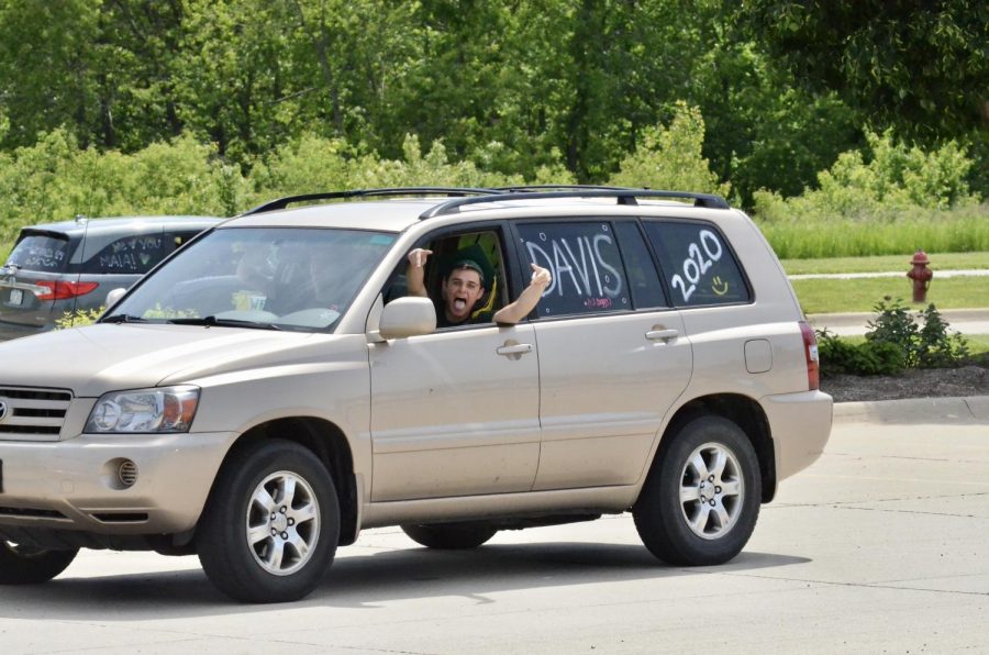 Davis Larson '20 drives along the route of the car parade to celebrate his graduation.