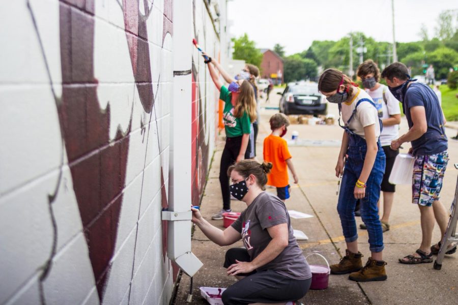 Many families get to work on the red section of the mural
