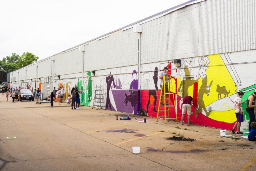 Community members work on a public mural in the South Side district of Iowa City.