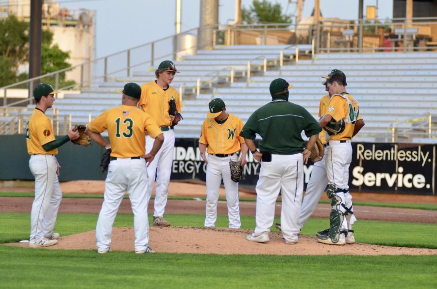 The Trojans infield regroups during a mound visit at Veterans Memorial Stadium on July 17. 