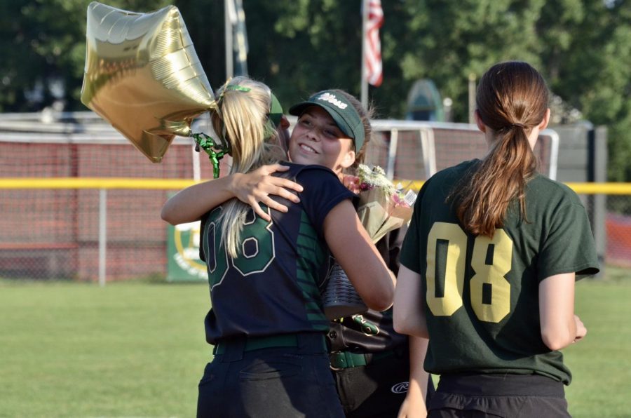 Ashley Dyson 21 hugs senior Kate Sehr as she walks out on the field with her family.