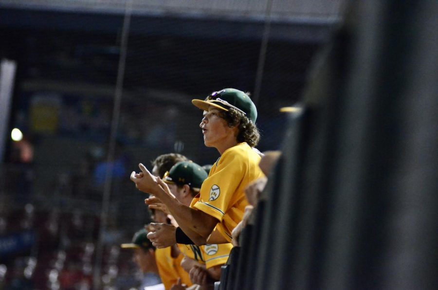 Noah DeSaulniers '22 cheers on his teammates from the dugout at Veterans Memorial Stadium on July 17. 