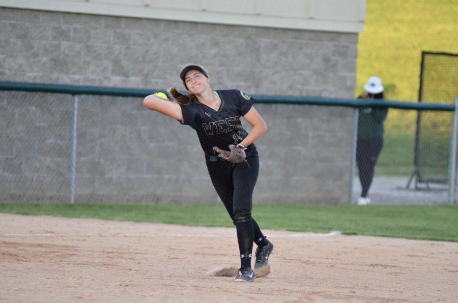 Shortstop Maddie Caylor 22 throws a line drive to Liv Williams 21 on first. 