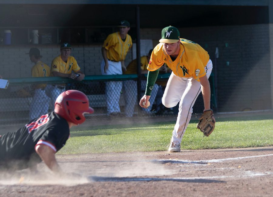Collin Leavy 20 attempts to tag a City High runner at home plate July 10.