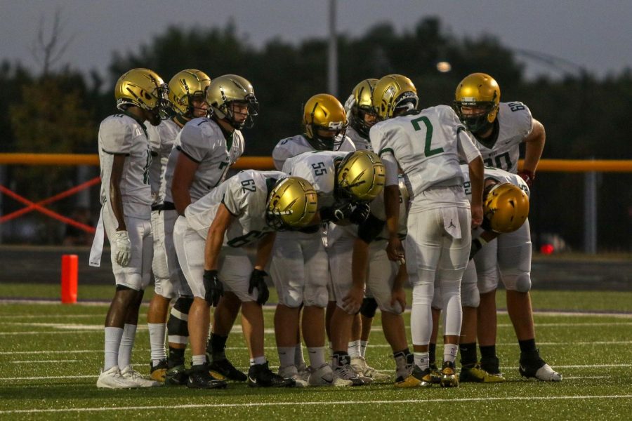 The offense huddles before their first drive of the night against Liberty on Aug. 28.