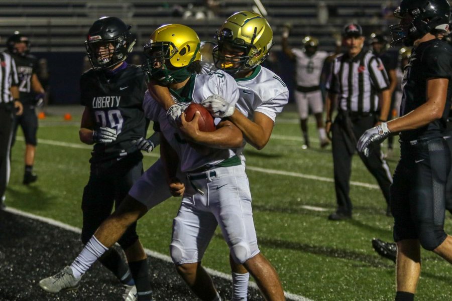 Trey King '21 and Eric Torres '21 celebrate King's touchdown run against Liberty on Aug. 28.