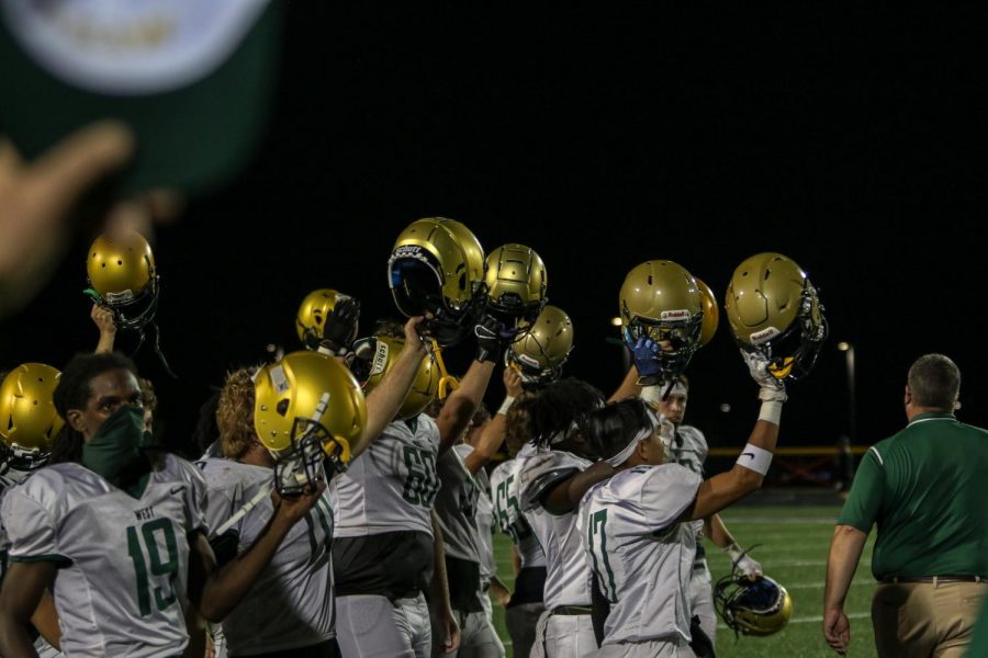 Players raise their helmets to Liberty after the game in replacement of the handshake line on Aug. 28.