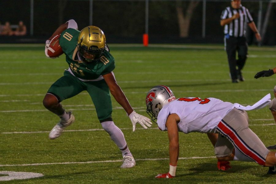 Damarion Williams '21 stiff arms a defender during the Battle for the Boot on Sept. 4.