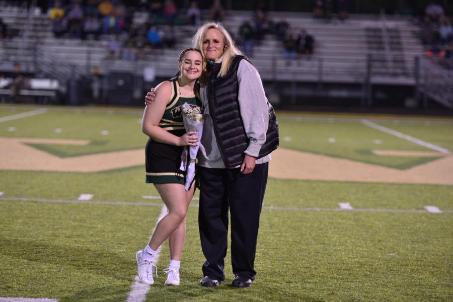 Senior Ariana Warson is joined by her mom at the 50-yard line celebrating her last year of West High cheer.