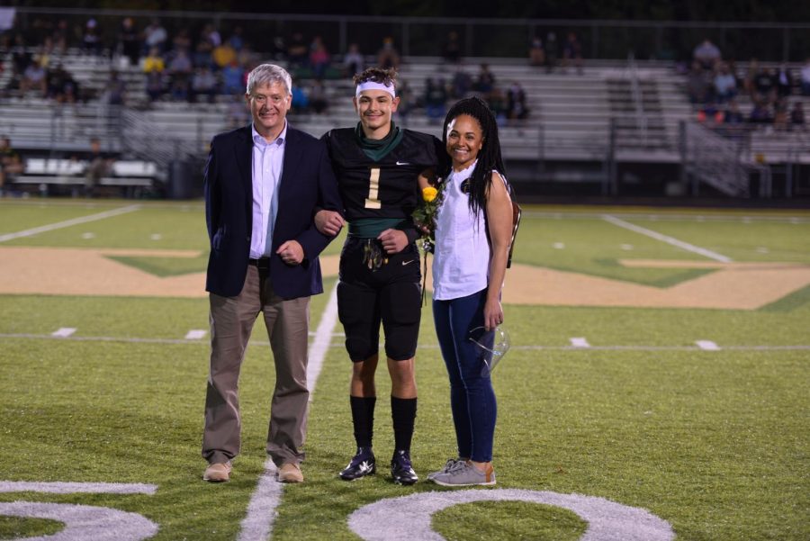 Senior Zach Anderson is joined by his parents on the field being recognized during senior night on Oct. 10. 