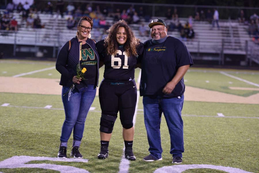 Senior Phoebe Burt is joined by her parents receiving recognition for being a part of West Football.
