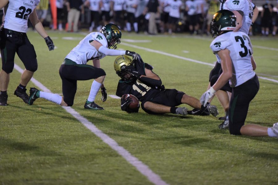 Eric Torres 21 holds onto the football as he slides down ending the play against Kennedy on Oct. 10.
