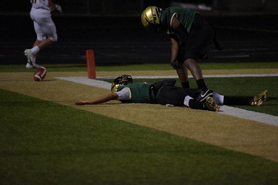 Marcus Morgan 21 lies on the Trojan Field after a touchdown late in the fourth quarter. Morgans touchdown secured the Trojans win over the Mustangs, advancing the team to the state quarterfinals.