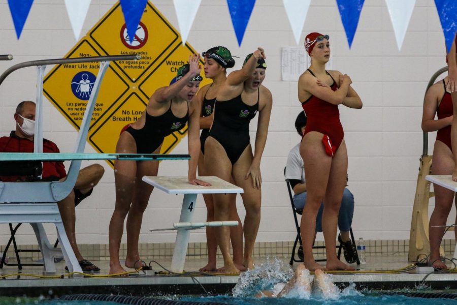 Olivia Taeger '22 and Ella Hochstetler '22 cheer on Aurora Roghair '21 during the 400 free relay at the Mercer Park Aquatic Center Oct. 17.