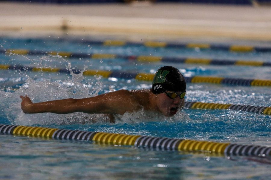 Holden Carter '24 swims in the 100 Butterfly against Waterloo on Dec. 15 at the Coralville Rec Center.