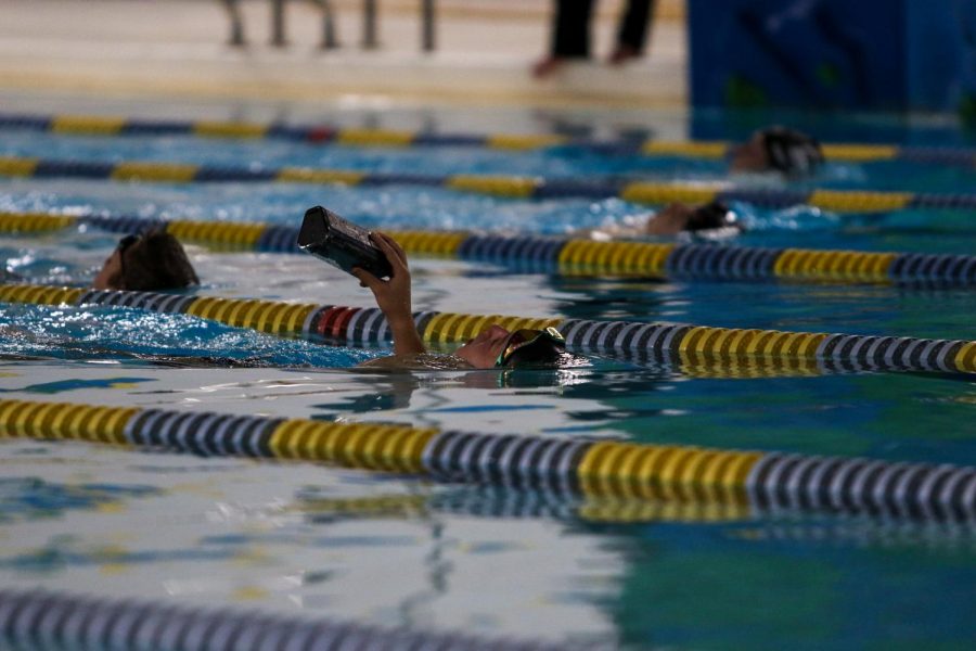 Holden Carter '24 swims his mask to the other end of the pool against Waterloo on Dec. 15 at the Coralville Rec Center.