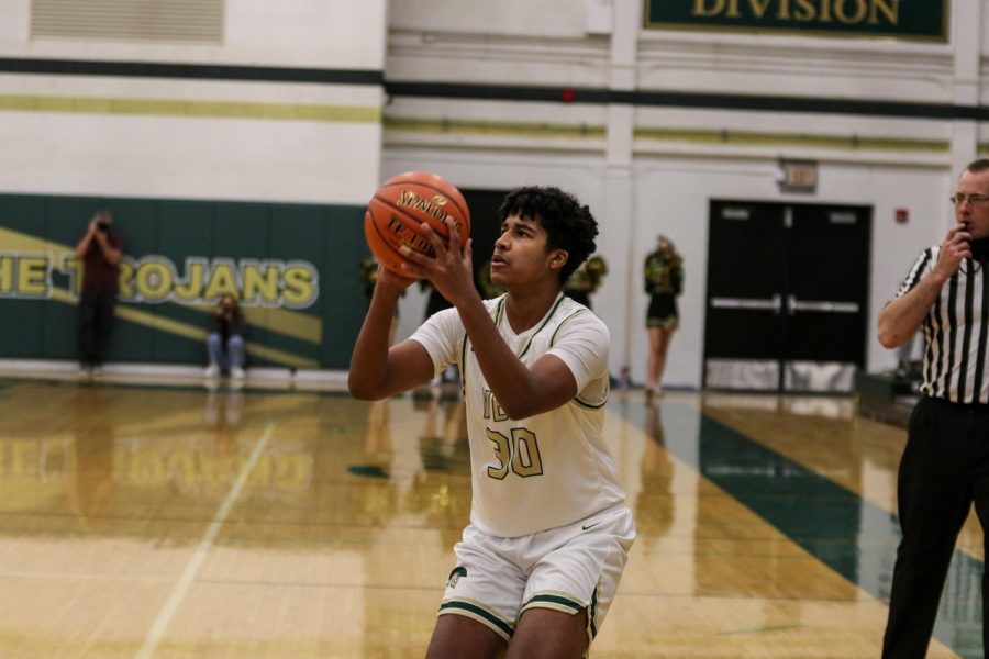 Savion Taylor '23 knocks down a three on the first possession of the game against City High on Dec. 18.