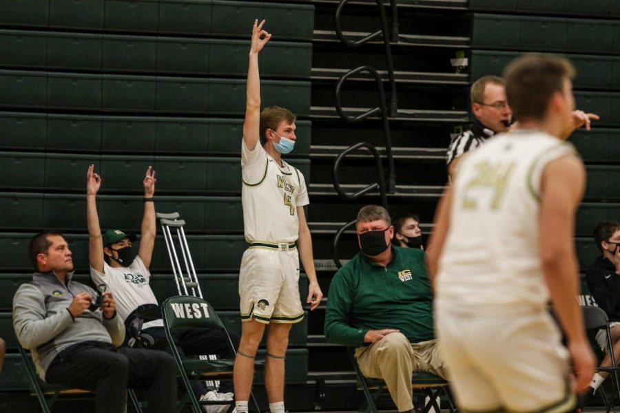 Andrew Tauchen '21 celebrates a three pointer from the bench against City High on Dec. 18.