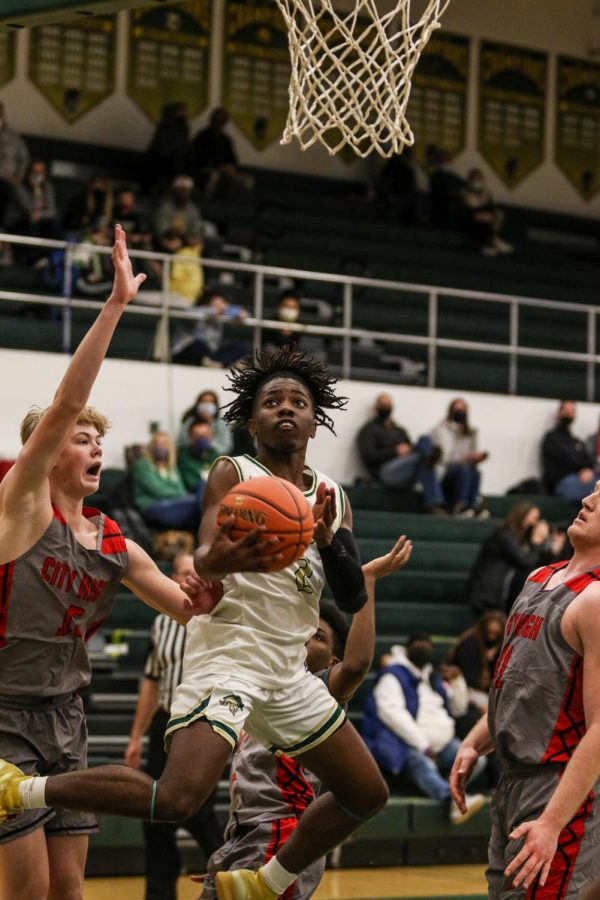 Christian Barnes '22 goes up for an acrobatic layup against City High on Dec. 18.