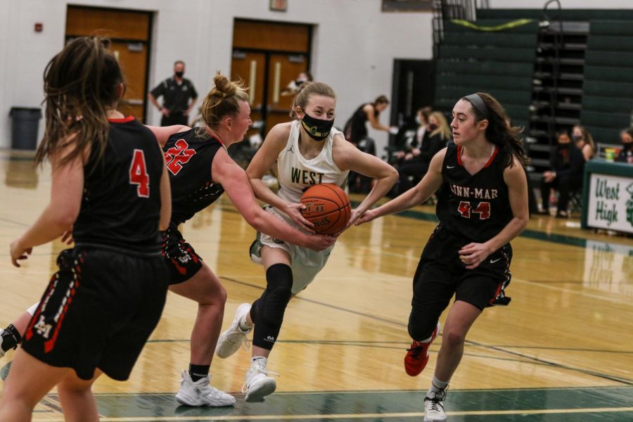 Lucy Wolf '24 breaks as double team as she drives into the lane against Linn-Mar on Dec. 22. 