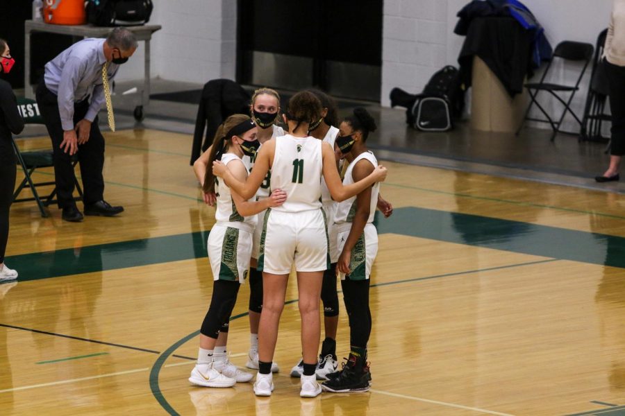 The starting lineup huddles before tip versus Dubuque Hempstead on Jan. 12.