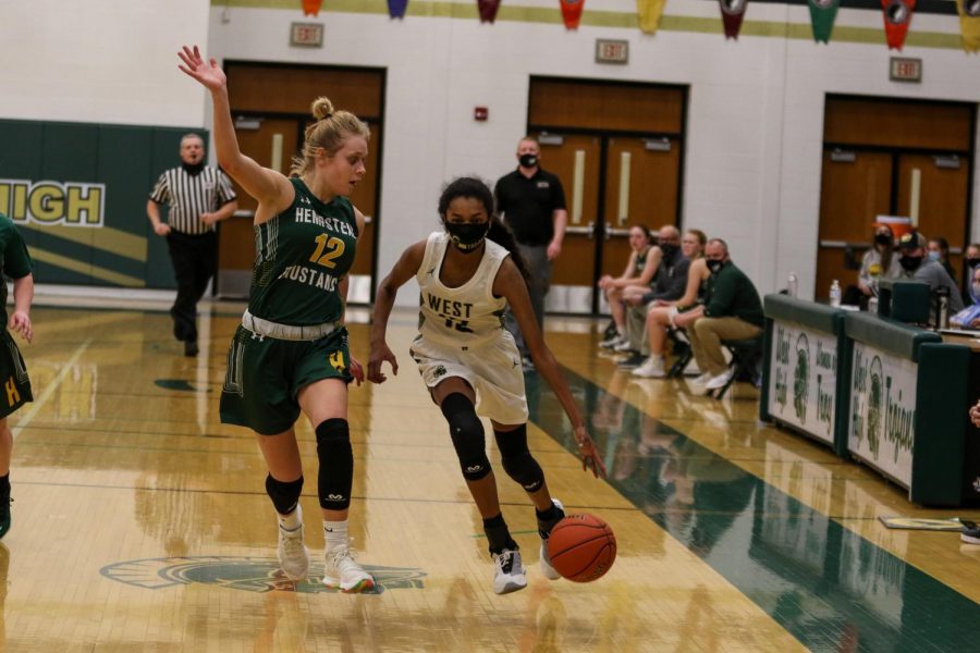 Meena Tate '23 pushes the ball up the sideline versus Dubuque Hempstead on Jan. 12.