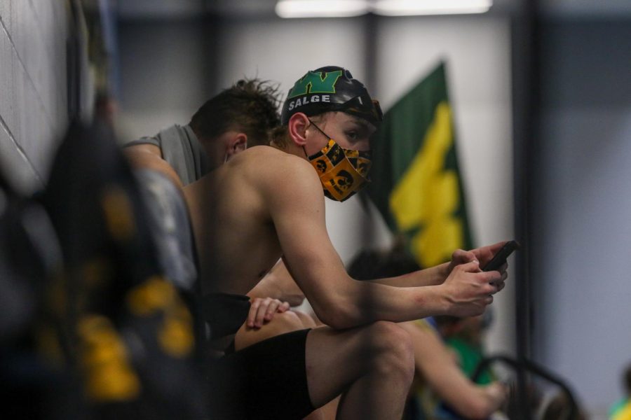 Dylan Salge '23 watches his teammates swim during a dual meet against Cedar Rapids Washington on Jan. 14.