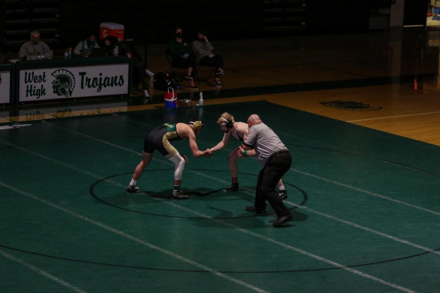 Ashton Barker shakes hands with his opponent before wrestling on Jan. 21.