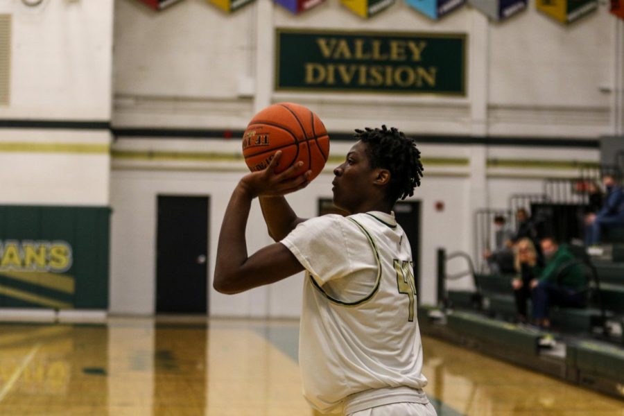 Antoine Tellis '22 shoots from beyond the arch against Burlington on Jan. 2.