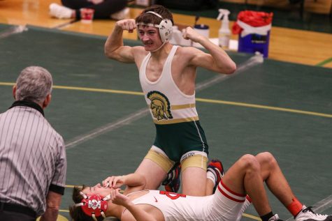 Parker McBride 22 flexes after winning the district championship at 120 pounds on Feb. 13.