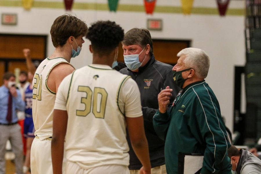 Head coach Steve Bergman talks to Pete Moe '22 during a timeout against Cedar Rapids Washington on Feb. 16.