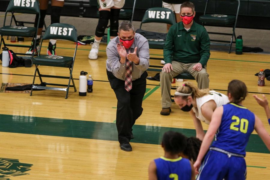 Head coach BJ Mayer cheers on Meena Tate '23 after fighting for a loose ball against Davenport North during the substate final game on Feb. 23.