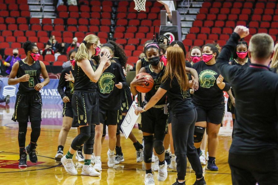 Matayia Tellis '21 and the rest of the team celebrate their win after the state quarterfinal game against Waterloo West on March 1.