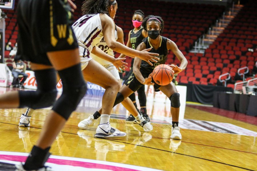 Matayia Tellis '21 passes the ball to Meena Tate '23 during the state quarterfinal game against Waterloo West on March 1.