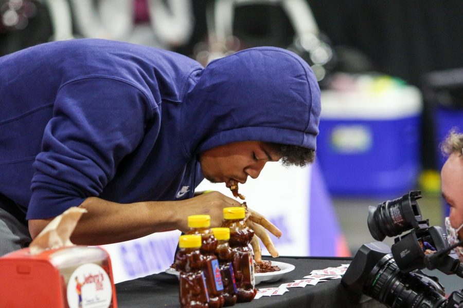 Davonte Morris '23 competes in a chicken wing eating contest at halftime of the state quarterfinal game against Waterloo West on March 1.