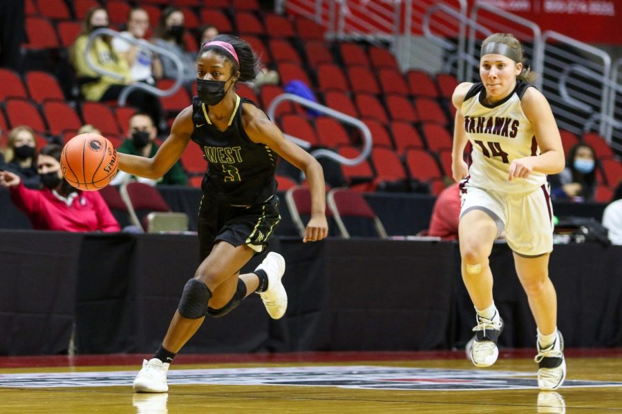 Matayia Tellis '21 pushes the ball up the floor looking to score during the state quarterfinal game against Waterloo West on March 1.