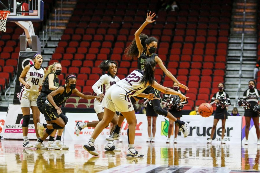 Meena Tate '23 reaches for a steal during the state quarterfinal game against Waterloo West on March 1.