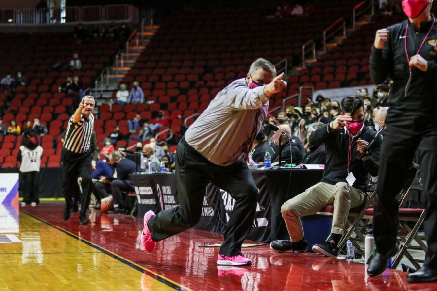 Head coach BJ Mayer points in the direction of the Trojans possession during the state quarterfinal game against Waterloo West on March 1.