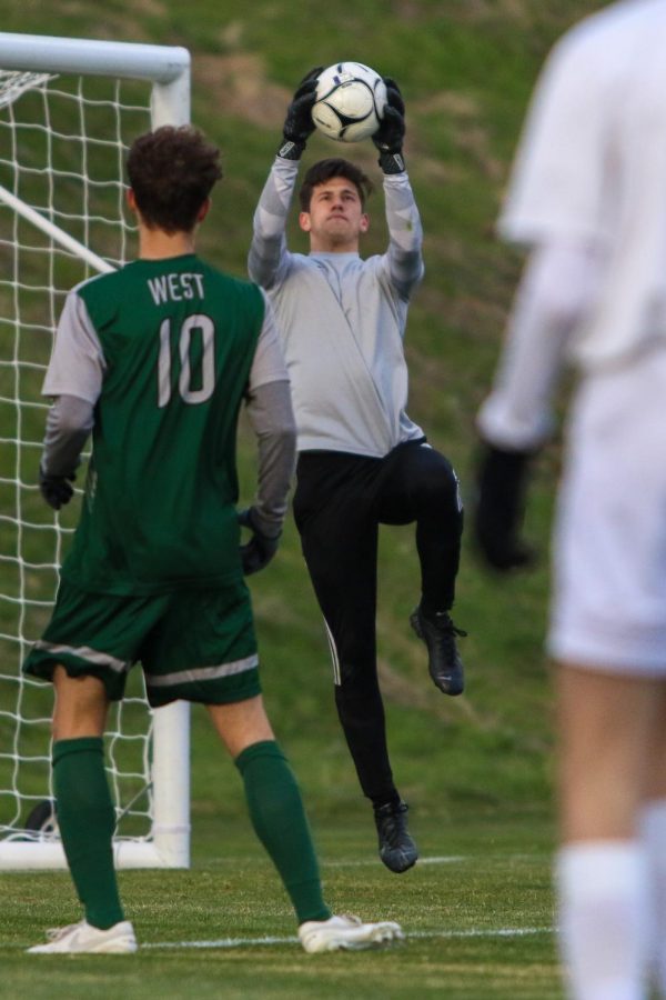 Nick McDonnell '22 jumps into the air to make a save against Linn-Mar on April 20 at Ed Barker Field.