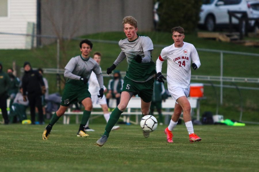 Tyler Johnson '21 runs down a loose ball as he looks to pass against Linn-Mar on April 20 at Ed Barker Field.