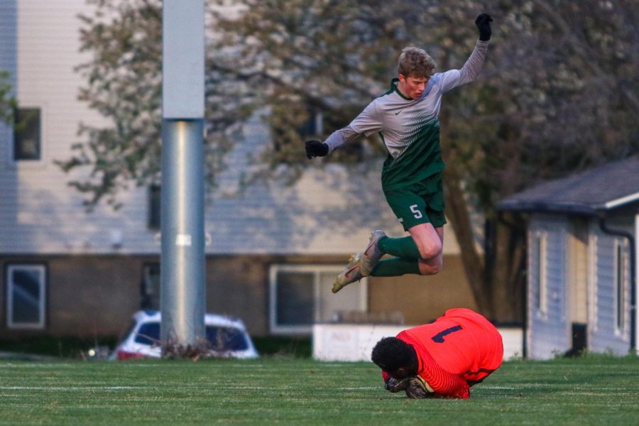 Tyler Johnson '21 leaps over the Linn-Mar keeper after making on April 20 at Ed Barker Field.