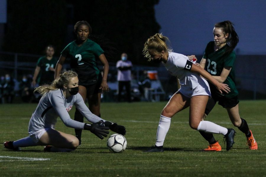 Kenadee Showalter '22 fights for a chance at the ball against City High at Ed Barker Field on April 22.