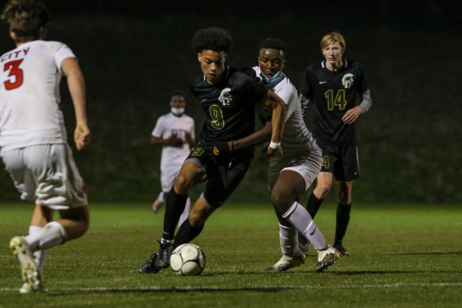 Kolby Godbolt '21 fights through the contact looking to score late against City High at Ed Barker Field on April 23. 