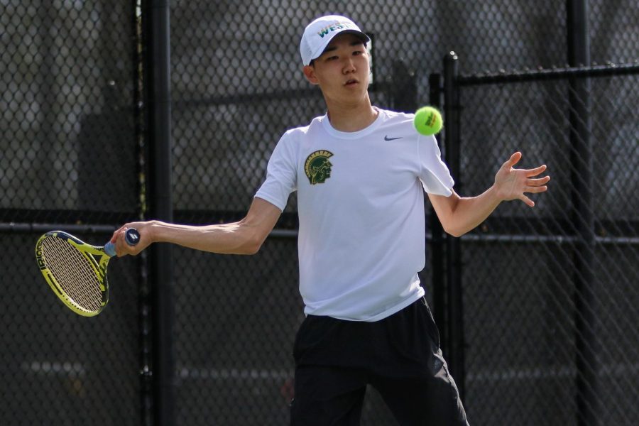 Jayden Shin '23 stares down the ball as he prepares to swing against City High at the Hawkeye Tennis and Recreation Center on April 29.