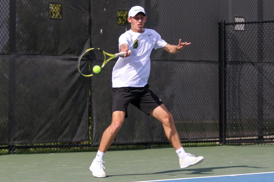 Eli Young '21 returns the ball for a point against City High at the Hawkeye Tennis and Recreation Center on April 29.