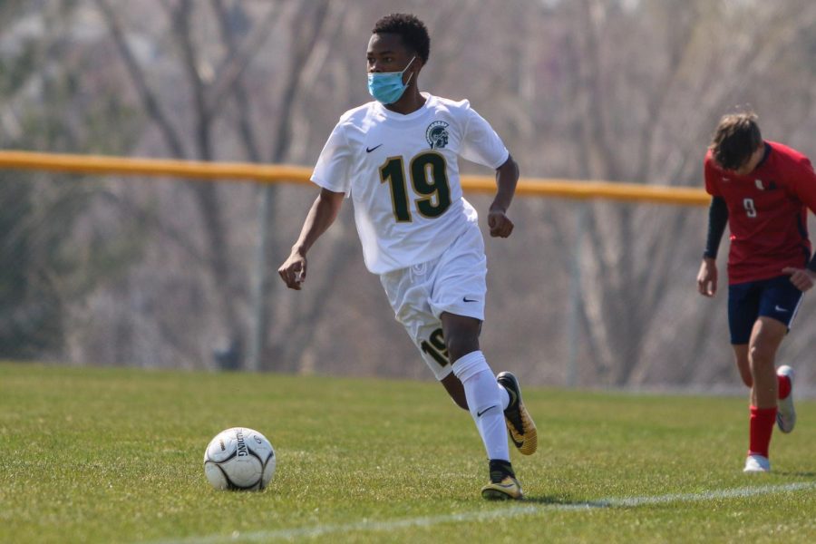 Ben Nkolobise '22 looks to pass against Urbandale on April 3 during the Iowa City West Classic.