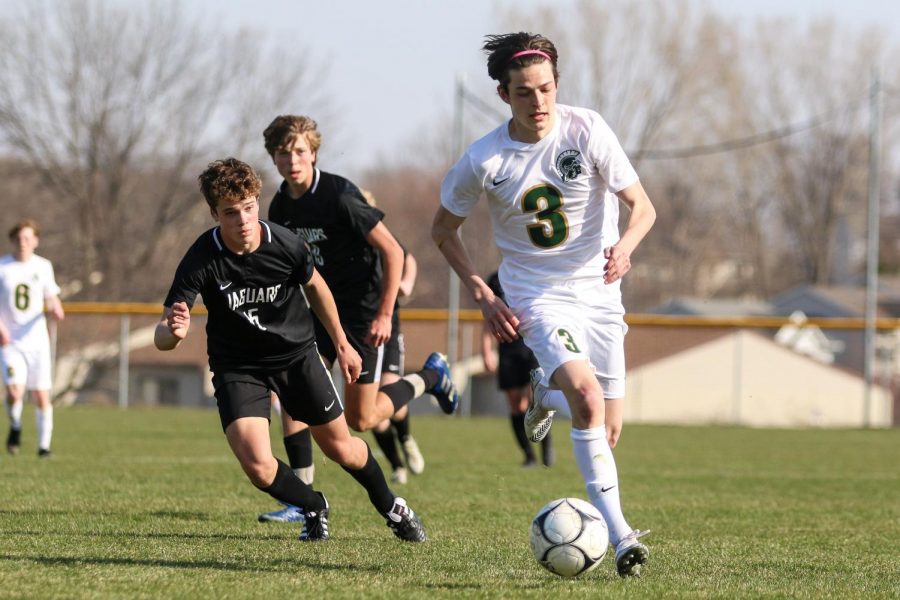 Matthew Steinbronn '21 looks to advance the ball against Ankeny Centennial on April 3 during the Iowa City West Classic.