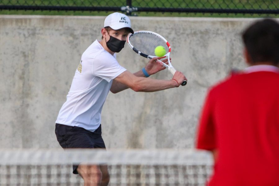 BJ Wolf '21 looks to score with his backhand while playing doubles against Cedar Falls on April 6.