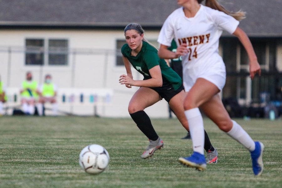 Jada Dachtler '22 eyes the ball as she gets back on defense against Ankeny on April 6.