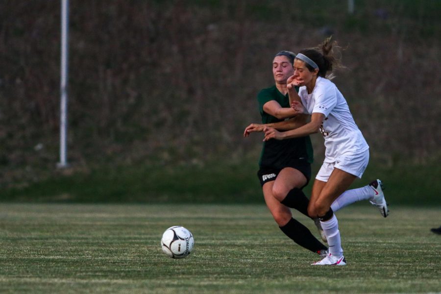 Jada Dachtler '22 collides with her defender while fighting for possession against Ankeny on April 6.